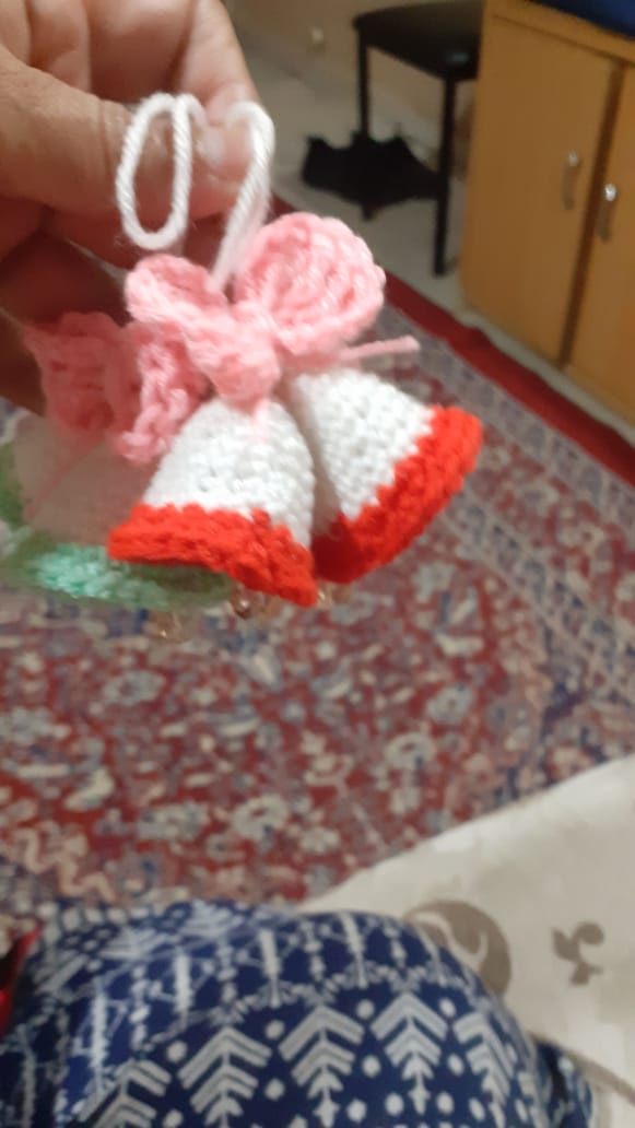 Jingle Bell Pair — red and white crocheted Christmas bells with a pink bow