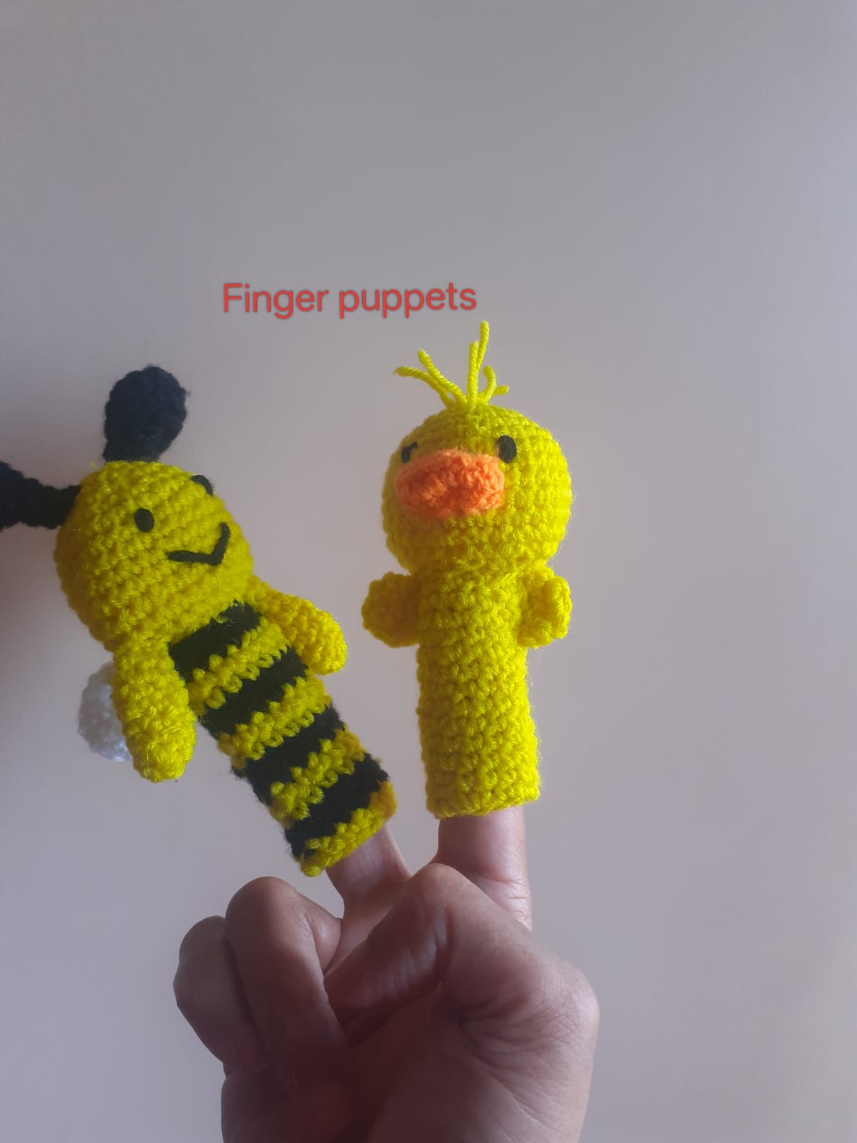 Finger Puppet — a pair of crocheted finger puppets, a yellow bee and a yellow duck