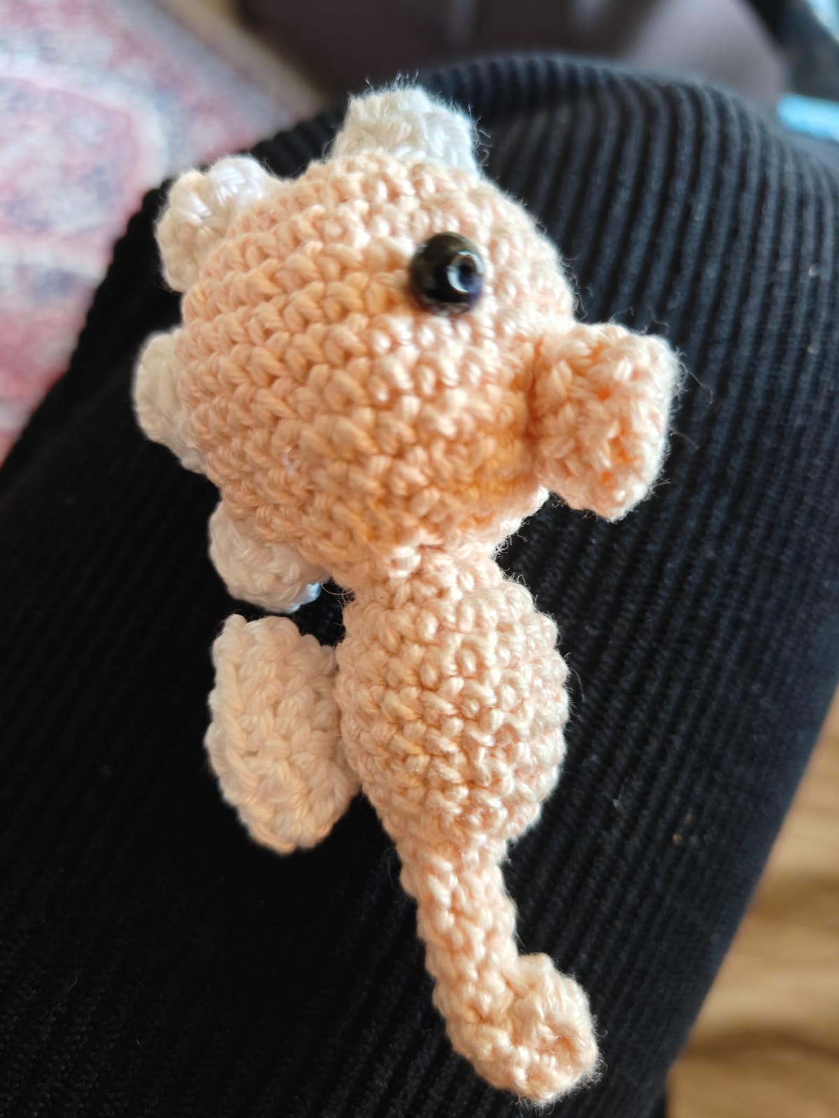 Pearl the Seahorse — a peach-coloured crocheted seahorse amigurumi with a curled tail and bead eye