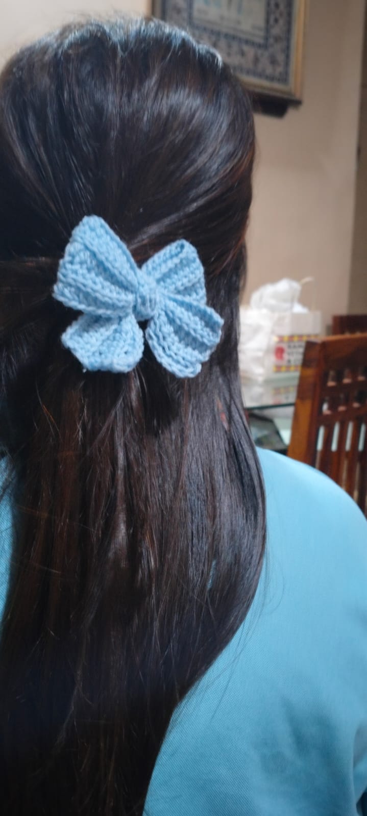 Bluebell Hair Bow — a soft blue striped crocheted bow worn in long dark hair
